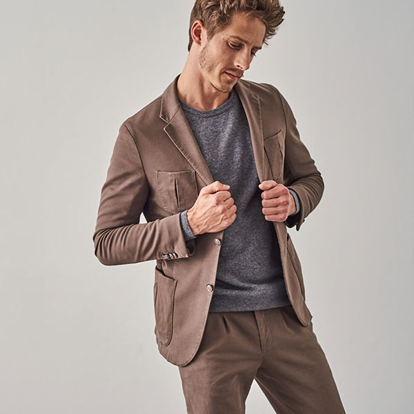 Ein blonder Mann in einem braunen Anzug mit Hose